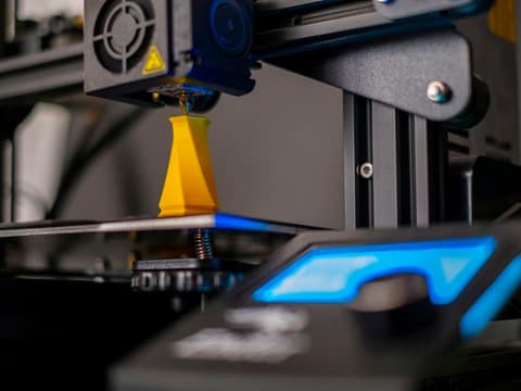 Gros plan sur la buse qui dépose une pièce jaune