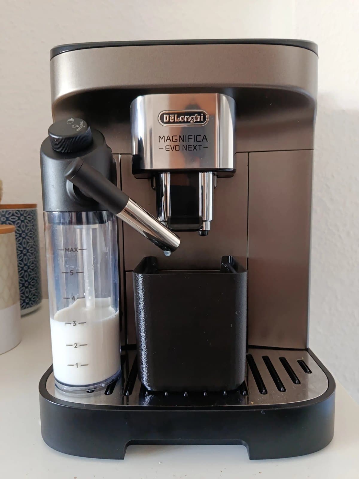 Récupérateur de gouttes noir texturé posé sous la buse d'une machine à café